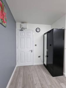 um quarto com uma porta preta e um relógio na parede em Bvapartments-Queensgate em Huddersfield