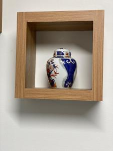 a vase is sitting on a wooden shelf at Bvapartments-Queensgate in Huddersfield