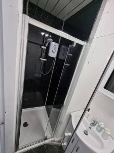 een badkamer met een douche, een wastafel en een spiegel bij Bvapartments-Queensgate in Huddersfield