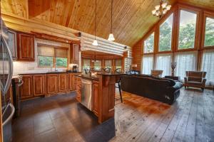 a kitchen with wooden cabinets and a living room at Grande Forêt by Tremblant Platinum in Mont-Tremblant