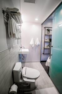 ein Badezimmer mit Toilette und Glasdusche in der Unterkunft SOVA Micro-Room & Social Hotel in Dallas