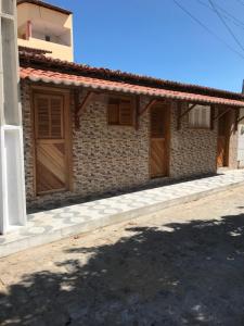 - un bâtiment avec des portes en bois sur le côté dans l'établissement Pousada O Mineiro - frente para o rio, à Galinhos