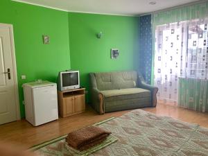 a green living room with a couch and a tv at Комфортабельный коттедж in Svityazʼ +27 photos