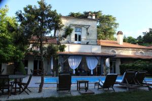 a house with chairs and a table next to a pool at Château la Moune in Montussan