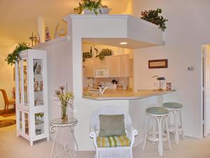 a kitchen with a counter and stools in a room at Quiet, gated community with pool and tennis courts in Marco Island