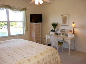 a bedroom with a bed and a desk and a television at Quiet, gated community with pool and tennis courts in Marco Island