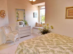 a bedroom with a bed and a tv and a mirror at Quiet, gated community with pool and tennis courts in Marco Island