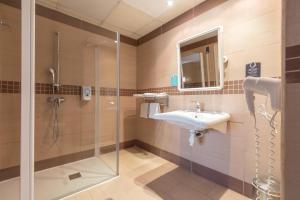 a bathroom with a shower, sink, and tub at Hotel Alda Zaragoza Independencia in Zaragoza