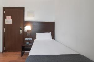a hotel room with a bed and a desk at Hotel Alda Zaragoza Independencia in Zaragoza