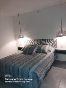 sypialnia z łóżkiem z dwoma światłami powyżej w obiekcie La Rosa de Tilcara w mieście Tilcara