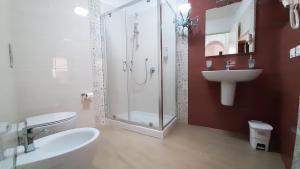 een badkamer met een douche, een toilet en een wastafel bij Corte Roma 148 Apt in Siracusa