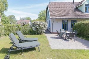 een patio met stoelen en een tafel voor een huis bij Ferienhaussiedlung Strandperlen Sanddornhof 5a (Typ IV) in Wustrow