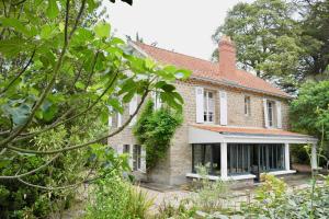 an exterior view of a brick house with trees at 700m de la plage des Dames - Maison pour 9 in Noirmoutier-en-l'lle