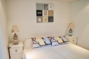 a bedroom with a bed with two night stands and two lamps at 700m de la plage des Dames - Maison pour 9 in Noirmoutier-en-l'lle
