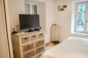 a bedroom with a flat screen tv on a dresser at 700m de la plage des Dames - Maison pour 9 in Noirmoutier-en-l'lle