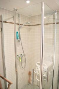 La salle de bains est pourvue d'une douche et de carrelage blanc. dans l'établissement Magnifique maison à Noirmoutier, moderne et spacieuse, à Noirmoutier-en-l'lle