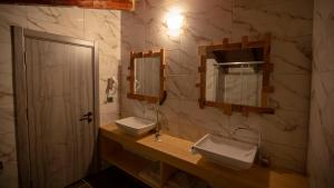a bathroom with two sinks and a mirror at İspendam Tess Otel in Macka