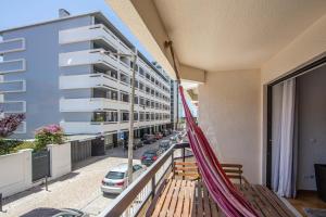 una hamaca en el balcón de un edificio en Caparica Luxury Apartment by HOST-POINT, en Costa da Caparica