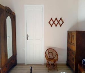 a room with a white door and a wooden chair at Kissamos Grandfather's House in Kissamos