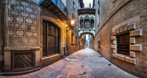 an empty alleyway between two buildings with an archway at OLD TOWN! Beach! in Barcelona