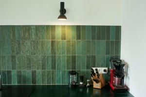 a kitchen counter with a green tiled wall at Gemütliche Wohnung mit Balkon in Deidesheim