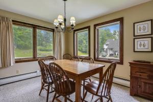 a dining room with a table and chairs and windows at Sunrise West Glade K1 in Killington