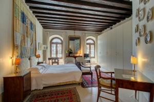Schlafzimmer mit einem Bett, einem Tisch und Stühlen in der Unterkunft TRIBUNO Grand Canal in Venedig