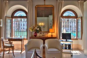 ein Wohnzimmer mit 2 Fenstern und einem Spiegel in der Unterkunft TRIBUNO Grand Canal in Venedig