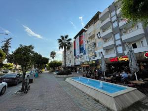 a city street with a swimming pool in front of a building at Prestij Suit in Alanya