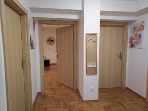 korytarz z dwoma drzwiami i drewnianą podłogą w obiekcie APART- salon z aneksem kuchenym, 2 sypialnie, łazienka w Szczecinie