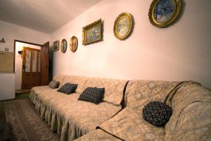 ein Wohnzimmer mit Sofa und Bildern an der Wand in der Unterkunft Mountain Village House in Čukljenik in Niš