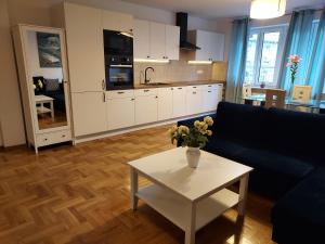 een woonkamer met een bank en een tafel bij APART- salon z aneksem kuchenym, 2 sypialnie, łazienka in Szczecin