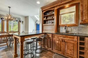 a kitchen with wooden cabinets and a bar with stools at Sunrise East Glade C8 in Killington