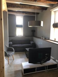 a living room with a couch and a tv at Fachwerk-Maisonette-Wohnung „Am Giebel“ in Rieste