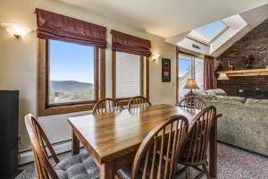 comedor con mesa de madera y sillas en Sunrise Timberline K2, en Killington