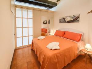 1 dormitorio con 1 cama grande con sábanas de color naranja en La casetta 2, en Roma