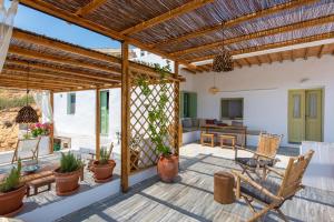 an outdoor patio with a pergola and chairs at Psarona Hospitality in Cherronisos