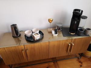 a table with cups and coffee makers on top of it at Le 43-3 avec sauna privatif in Le Puy en Velay
