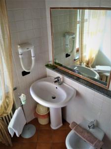 une salle de bain avec un lavabo et un miroir dans l'établissement Cascina Creusa B&B, à Pocapaglia