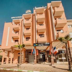 un grand bâtiment avec des palmiers devant lui dans l'établissement EL MOUSSAFIR HOTEL, à Marrakech