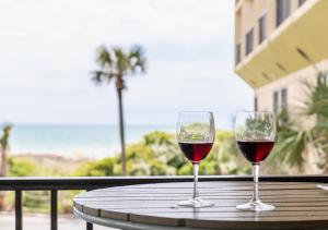 two glasses of wine sitting on a table on a balcony at Surfside Beach Oceanfront Hotel in Myrtle Beach