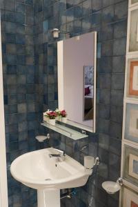 ein Bad mit einem Waschbecken und einem Spiegel in der Unterkunft Frebi's Home - Bed & Breakfast in Neapel