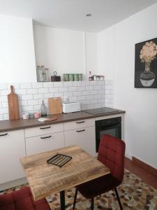 a kitchen with a wooden table and red chairs at Le 43-3 avec sauna privatif in Le Puy-en-Velay