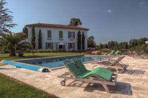 uma piscina com espreguiçadeiras e uma casa em Domaine du Beau Rivage em Le Temple-sur-Lot