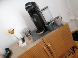 a counter with a coffee maker and cups on it at Le 43-3 avec sauna privatif in Le Puy-en-Velay