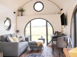 a living room in a tiny house with an arched window at Cherry Blossom in Craven Arms