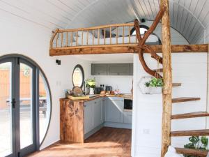 uma cozinha com uma cama alta numa pequena casa em Cherry Blossom em Craven Arms