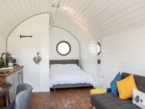 um quarto com uma cama e um sofá num quarto em Withy Willows em Craven Arms