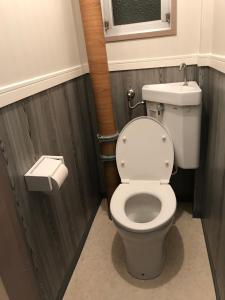 a bathroom with a white toilet and a window at Kurosaki Guesthouse 403 in Kitakyushu