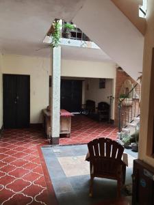 a living room with a red tile floor and a staircase at Hotel Acatenango Inn in Antigua Guatemala